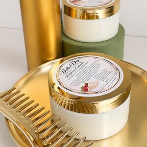 May include: A gold-colored hair care set featuring a spray bottle, comb, and jars of cream. The jars have gold lids and white cream. The comb and tray are also gold. The set is arranged on a white surface.