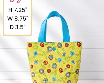 May include: A small tote bag with a floral pattern on a yellow background. The bag has blue handles and is 7.25 inches high, 8.75 inches wide, and 3.5 inches deep. The bag's design features colorful flowers and green leaves.