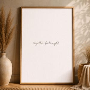 Può includere: Stampa incorniciata con la frase "together feels right" in una scrittura delicata. La stampa ha una palette di colori neutri ed è incorniciata in una cornice dorata. L'immagine è impreziosita da elementi decorativi.