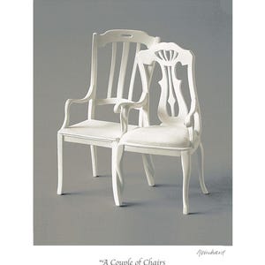 May include: Two white wooden chairs with intricate carvings on the backs. The chairs are positioned next to each other, with one slightly behind the other. The chairs are on a gray background. The text "A Couple of Chairs" is written below the chairs.