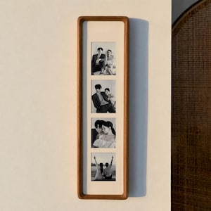 May include: A vertical wooden picture frame with four black and white photographs. The frame has a light wood finish and a cream-colored matting. The photos depict couples in various poses.