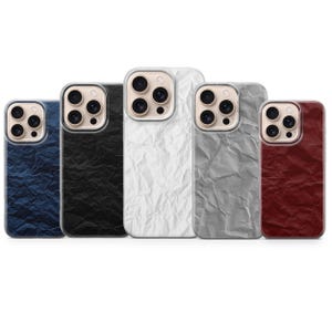 May include: Five phone cases in a row, each with a unique color and texture. The cases are in shades of blue, black, white, gray, and burgundy. The texture resembles crumpled paper.