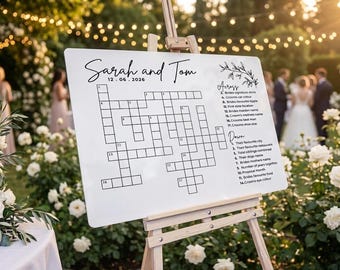May include: A white rectangular sign on a wooden easel featuring a black crossword puzzle, the names Sarah and Tom, the date 12.06.2026, and two lists of clues labelled Across and Down. The sign has a black line drawing of a leafy branch at the top.
