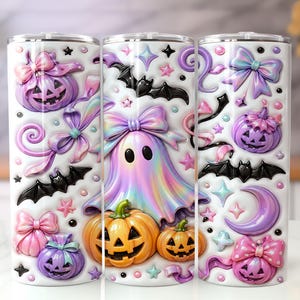 May include: Three cylindrical tumblers featuring a white background with a repeating pattern of pastel purple and orange jack-o'-lanterns, iridescent ghosts, black bats, pink bows, and small stars. Each tumbler has a clear lid and a smooth finish.