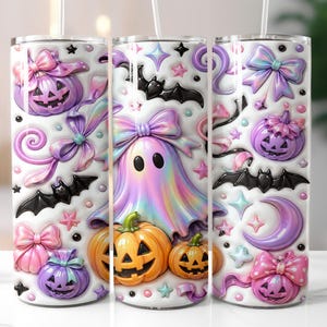 A trio of Halloween-themed tumblers, each adorned with a variety of spooky and festive decorations. The tumblers feature pumpkins, bats, ghostly figures, and other Halloween-related motifs, creating a whimsical and festive atmosphere.