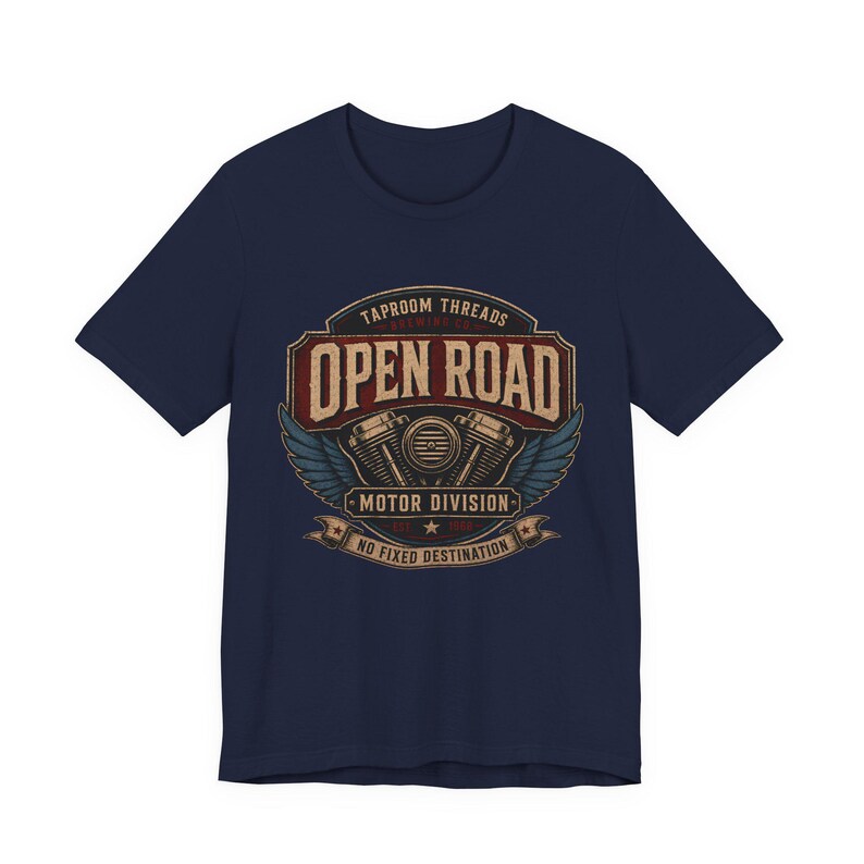 May include: Navy blue t-shirt with a distressed graphic featuring the text "OPEN ROAD" above a motorcycle engine design and wings. The shirt also includes the text "TAPROOM THREADS MOTOR DIVISION NO FIXED DESTINATION".