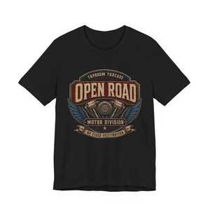 May include: Black t-shirt featuring a vintage-style graphic with the words "Open Road" in a distressed font. The design includes a motorcycle engine, wings, and the text "Motor Division" and "No Fixed Destination."