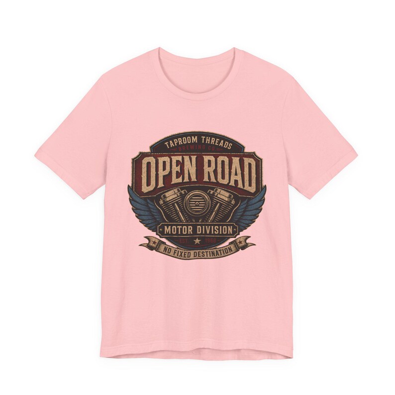 May include: A light pink t-shirt featuring a vintage-style graphic. The graphic includes the words "TAPROOM THREADS" and "OPEN ROAD MOTOR DIVISION" with a motorcycle engine illustration and the phrase "NO FIXED DESTINATION".