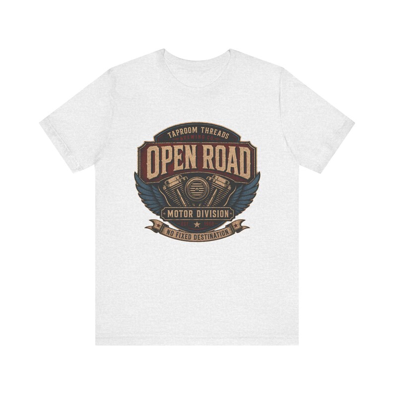 May include: A light gray t-shirt featuring a vintage-style graphic. The graphic includes the text "TAPROOM THREADS OPEN ROAD MOTOR DIVISION NO FIXED DESTINATION" with a motorcycle engine design and wings.