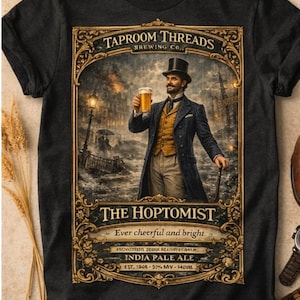 May include: Dark gray t-shirt featuring a vintage-style illustration. The design includes a man in a top hat holding a beer, with text that reads "TAPROOM THREADS BREWING CO." and "THE HOPTOMIST." The shirt also mentions "INDIA PALE ALE."