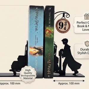 May include: Black metal bookends featuring a silhouette of a character pushing a luggage cart toward a Platform 9 3/4 sign. The set measures approximately 200 mm in height and 100 mm in width per piece, holding two Harry Potter book volumes.