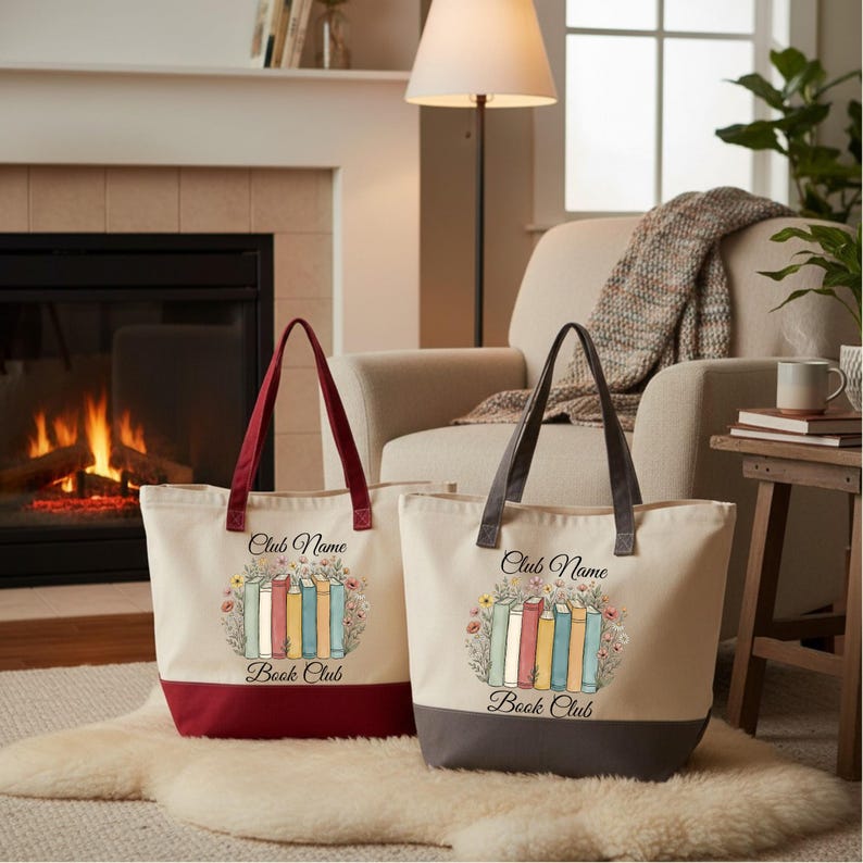 Two tote bags with a book club design are placed on a rug in front of a fireplace, with a lamp and a plant nearby.