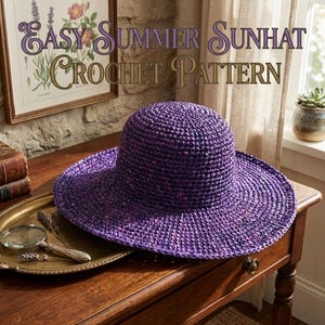 May include: A purple crochet sunhat with a wide brim sits on a wooden table. The hat is the focal point, with the text "Easy Summer Sunhat Crochet Pattern" above it. A vintage tray with a magnifying glass and books are also on the table.