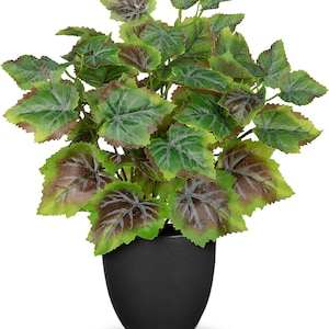 May include: A potted artificial plant featuring vibrant green leaves with dark brown centers and prominent light-colored veins. The foliage is arranged in a dense, rounded cluster and is housed in a smooth, matte black, rounded ceramic pot.