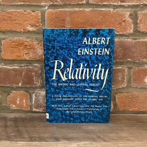 May include: A book titled Relativity: The Special and General Theory by Albert Einstein. The cover features a blue and black mottled pattern with white text. The subtitle reads A Clear Explanation of the Famous Theory That Brought About the Atomic Age.
