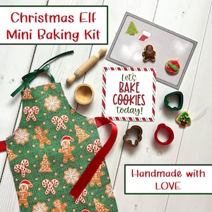 May include: A Christmas Elf Mini Baking Kit with a green apron featuring gingerbread men and candy canes. Includes a rolling pin, cookie cutters, and a sign that says "Let's BAKE COOKIES today!" Handmade with LOVE.