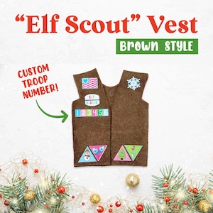 May include: Brown felt vest with a snowflake, heart, and "Elf Scouts" patches. The vest has a space for a custom troop number.