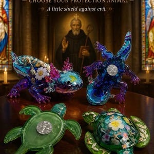 May include: Two axolotl and two turtle figurines featuring embedded floral and seashell designs. The axolotls are blue and purple, while the turtles are green. Each piece includes a silver Saint Benedict medal. Text reads: BENEDICT'S TINY GUARDIANS.