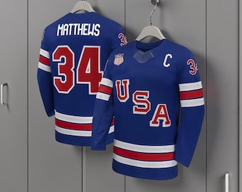Camiseta de hockey sobre hielo olímpica de Auston Matthews, selección de EE. UU., 2026 – Azul real, para hombre, con bordado de aficionado.