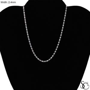 May include: A silver-colored necklace with a delicate chain design, displayed on a black mannequin. The chain's width is 2.4mm. The necklace is a simple, elegant piece of jewelry.