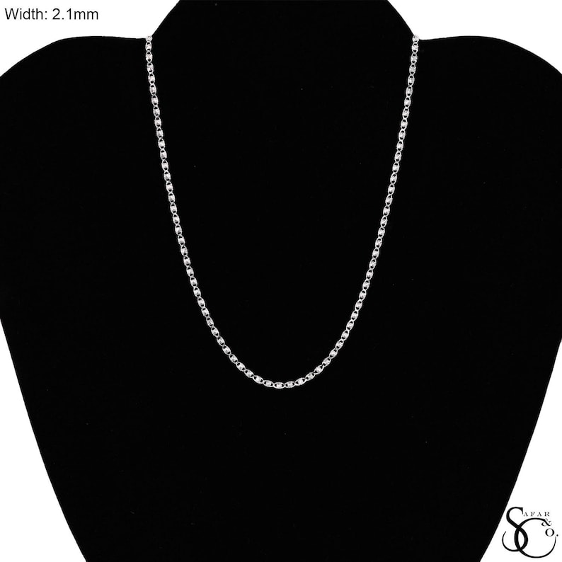 May include: A silver-colored chain necklace with a width of 2.1mm is displayed against a black background. The chain has a delicate, rectangular link design. The necklace is presented on a black jewelry display.