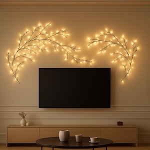 May include: Decorative wall-mounted light fixtures in the shape of branches with warm white LED lights. The branches are arranged on the wall above a black television. The room has a neutral color palette with a modern aesthetic.