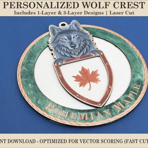 May include: A personalized wolf crest with a wolf head, shield, and maple leaf design. The crest is laser cut and includes 1-layer and 3-layer designs. The text "BOHEMIAN MAPLE" is displayed on the crest. The image also includes the text "INSTANT DOWNLOAD - OPTIMIZED FOR VECTOR SCORING (FAST CUTTING)".
