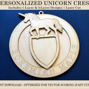 Puede incluir: Un escudo de unicornio de madera cortado con láser con un diseño de escudo. El escudo presenta un unicornio sobre un escudo, dentro de un marco circular. El texto "BOHEMIAN MAPLE" está grabado alrededor del borde. El diseño incluye opciones de 1 y 3 capas.
