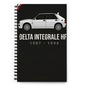 May include: A spiral-bound notebook with a black cover featuring a white illustration of a car. The text "DELTA INTEGRALE HF" and the years "1987 - 1994" are printed in white. A green, white, and red stripe is visible at the top.