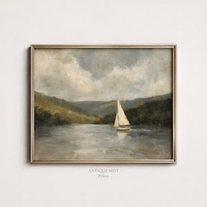 Puede incluir: Una pintura de paisaje enmarcada que muestra un velero blanco en aguas tranquilas. La escena incluye colinas verdes bajo un cielo nublado con tonos apagados. El texto "ANTIQUE MIST Prints" está impreso en negro debajo de la obra enmarcada.