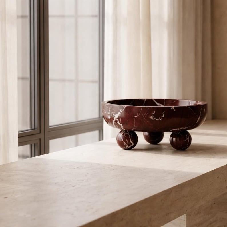 Pu&ograve; includere: Una tazza di ceramica bianca con manico nero e la scritta "But First, Coffee" in grassetto nero. La tazza &egrave; posta su uno sfondo sfocato. La tazza &egrave; alta circa 10 cm.