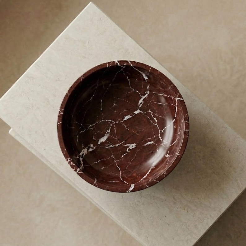Pu&ograve; includere: Un set di tre tazze in ceramica con finitura opaca e macchiettata. Le tazze sono nei toni del crema, grigio chiaro e grigio scuro. Ogni tazza ha un design semplice e minimalista e un manico arrotondato.