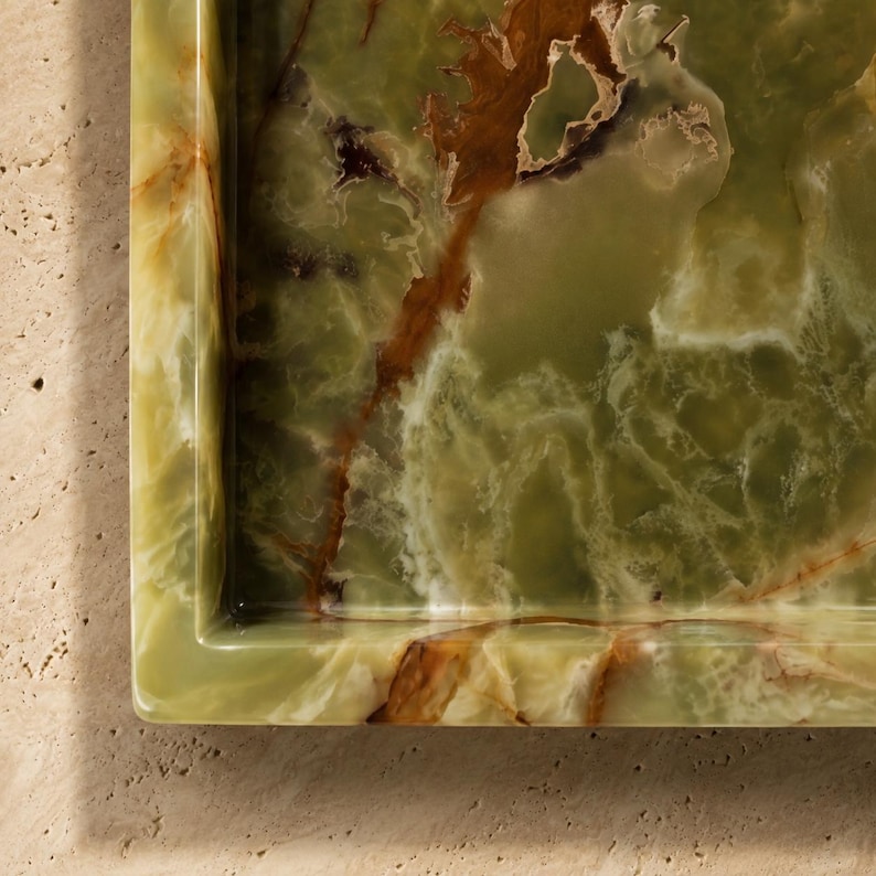 May include: A rectangular tray crafted from polished green onyx stone, featuring natural swirling patterns in shades of deep forest green, translucent pale olive, and dark brown veins, with a smooth, glossy finish and defined edges.