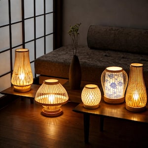 Puede incluir: Una taza de cerámica blanca con un asa negra y el texto "But First, Coffee" en negro, con una fuente de estilo manuscrito. La taza está sobre una superficie blanca.