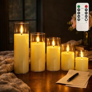 May include: A set of five flameless LED candles in clear glass cylinders, varying in height. The candles are a warm yellow color, with a flickering flame effect. A remote control is visible, offering timer and brightness settings.