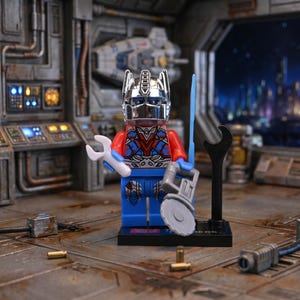 May include: A Lego figure of Optimus Prime, featuring a silver helmet and red, blue, and silver armor. The figure holds a white wrench and a gray saw, with a blue sword and black wrench on a stand. The figure stands on a black base.