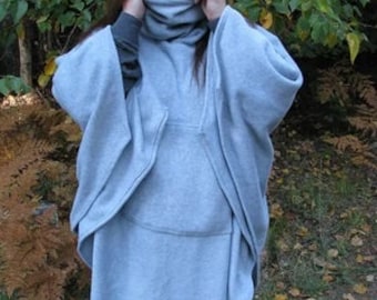 May include: A gray fleece poncho with a high neck and a long, flowing design. The poncho is made of a soft, comfortable fabric and is perfect for layering in the colder months.