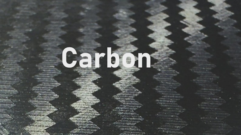 K&ouml;nnte beinhalten: Nahaufnahme eines Carbonfasergewebe-Musters. Das Bild zeigt ein sich wiederholendes, strukturiertes Design in Schwarz- und Graut&ouml;nen. Das Wort "Carbon" wird in Wei&szlig; mittig im Bild angezeigt.