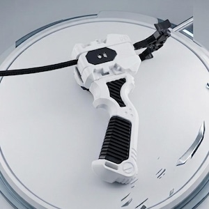 May include: A white and black Beyblade X launcher with a black grip and a black cord. The launcher is on a white circular platform with the text "BEYBLADE X" in silver.
