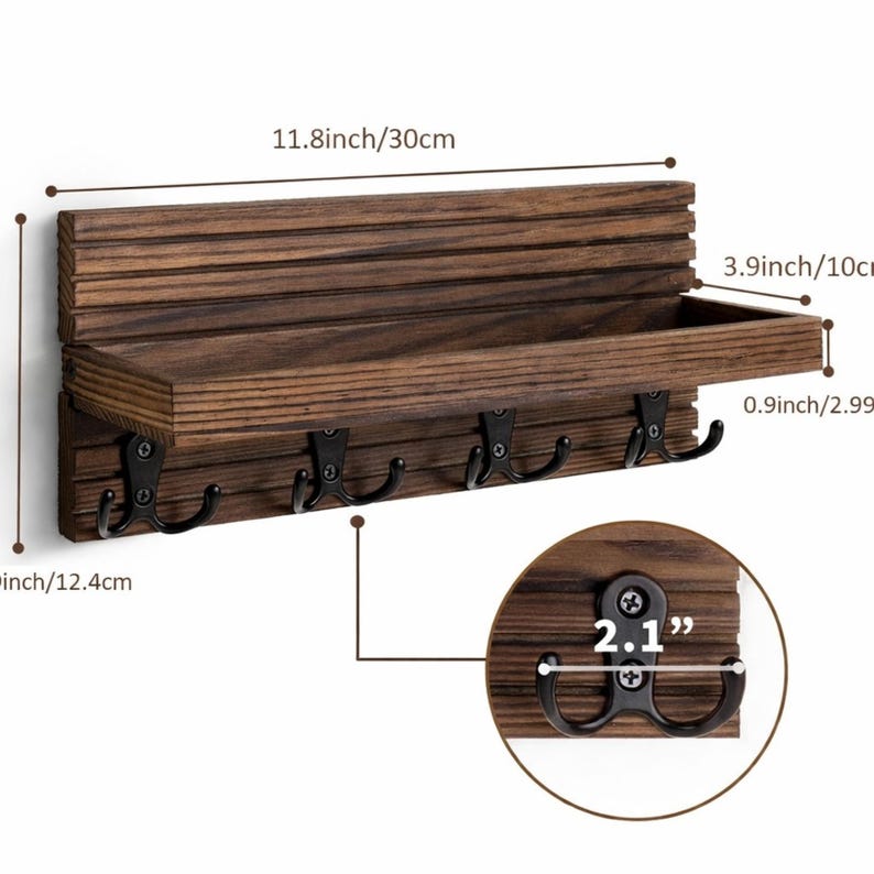 Puede incluir: Un llavero de madera marr&oacute;n oscuro con un estante y cinco ganchos de metal negro. El estante mide 30 cm de largo y 10 cm de profundidad. Los ganchos est&aacute;n separados por 5,3 cm. El llavero mide 12,4 cm de alto.