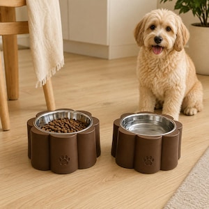 Pode incluir: Dois comedouros para animais de estimação castanhos em forma de flor com inserções de aço inoxidável. Um comedouro está cheio de ração seca e o outro com água. Cada um apresenta um pequeno desenho de pata em relevo na parte frontal.