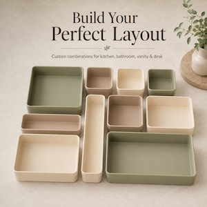 Könnte beinhalten: Eine Sammlung von rechteckigen und quadratischen Aufbewahrungsschalen in Salbeigrün, Beige und Taupe. Der Text "Build Your Perfect Layout" und "Custom combinations for kitchen, bathroom, vanity & desk" steht in dunkelbrauner Schrift darüber.