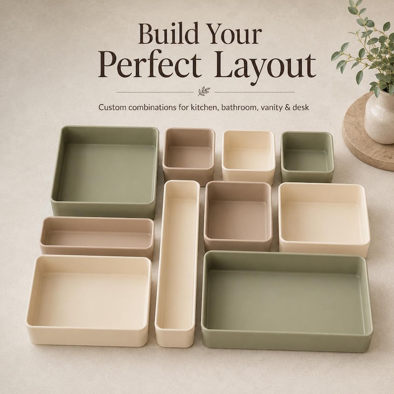 May include: A collection of rectangular and square storage trays in sage green, beige, and taupe. The text "Build Your Perfect Layout" and "Custom combinations for kitchen, bathroom, vanity & desk" is printed above the trays in dark brown font.