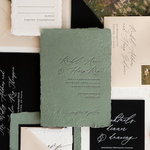 May include: Sage green wedding invitation with embossed floral details and elegant script. The invitation includes the names "Rachel Anne & Henry Ray" and event details. Additional stationery pieces are visible.