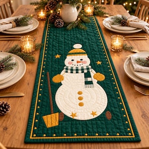 Peut inclure: Un chemin de table matelassé vert foncé rectangulaire orné d'un bonhomme de neige blanc en appliqué. Le bonhomme de neige porte un bonnet rayé jaune et blanc, une écharpe à carreaux verts et blancs et des moufles jaunes. Il tient une pelle jaune.