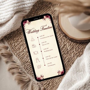 May include: A smartphone displaying a wedding timeline graphic with a cream background, dark red floral accents, and icons for a church, rings, cutlery, champagne glasses, and a disco ball, listing events from 11:00 AM to 6:00 PM in dark brown text.