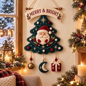 May include: A felt wall hanging featuring a dark teal Christmas tree with a Santa Claus face, red berries, and white pom-poms. A banner above reads MERRY & BRIGHT. Three dangling ornaments include a metal bell, a crescent moon, and a red gift box.