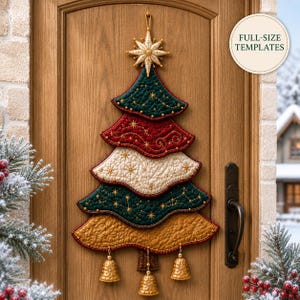 Op de afbeelding: Een gewatteerde stoffen kerstboom als wandhanger met lagen in donkergroen, rood, crème en goud, voorzien van gouden sterrenborduurwerk. Een gouden ster siert de top en drie gouden klokjes hangen onderaan. Tekst: FULL-SIZE TEMPLATES.