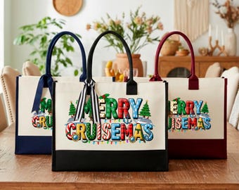 May include: Three rectangular canvas tote bags with black, navy, and maroon bases. Each bag features the text MERRY CRUISEMAS in colorful, patterned letters, decorated with Christmas trees, anchors, cruise ships, and string lights.