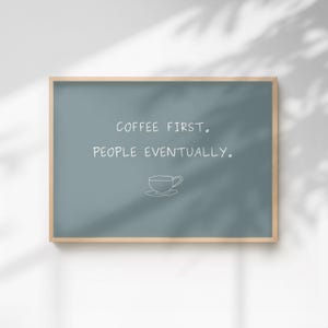 May include: A framed sign with a teal background and a light wood frame. The sign reads "COFFEE FIRST. PEOPLE EVENTUALLY." in white text, with a small coffee cup illustration below.